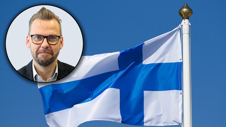 Den finska flaggan med en porträttbild av Jari Ollila monterad över