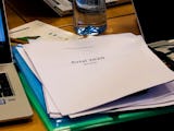 En bunt papper på ett mötesbord, med texten Avtal 2020 på omslaget