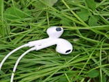 Ett par hörlurar som ligger i grönt gräs