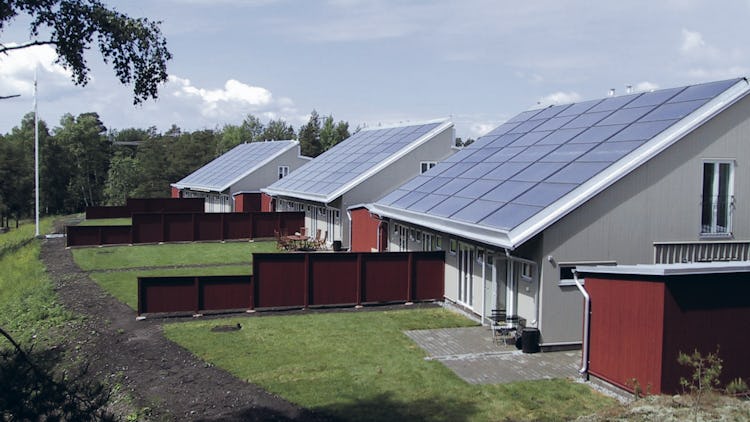 En rad hus med solpaneler på taken