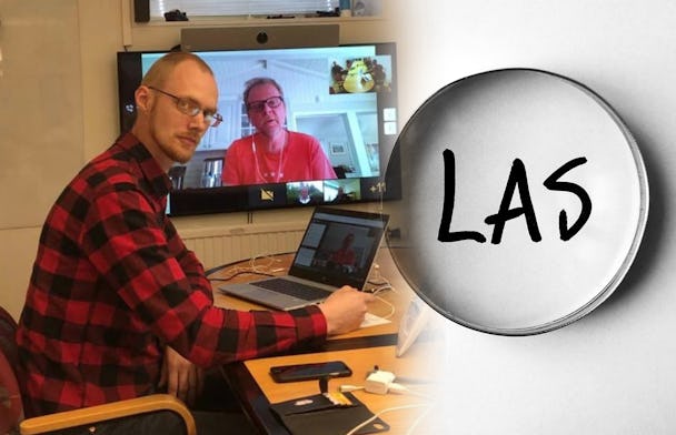 David Aura framför en dator med Urban Pettersson på skärmen. En bild på ett förstoringsglas som är riktat mot ordet LAS är monterad invid.