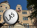 LO-borgen i Stockholm, med ett förstoringsglas som domar in på ordet "Las" monterat över