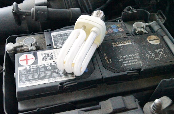 Ett bilbatteri med en energisparlampa på