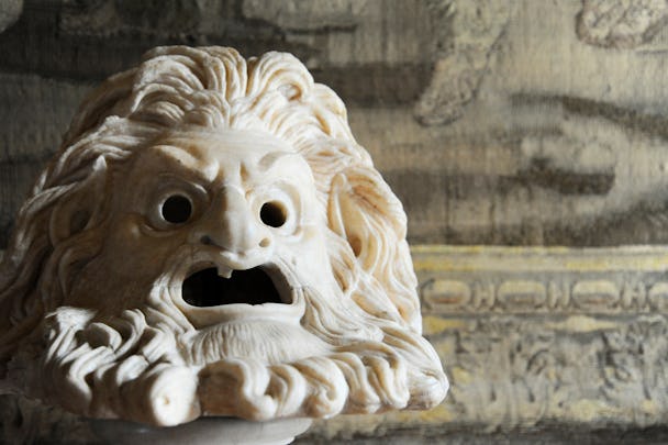 En grekisk antik skulptur av ett ilsket ansikte med svallande hår