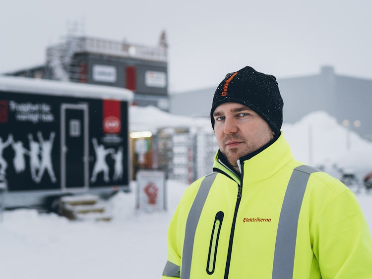 Mathias Hansson framför arbetarplatsens baracker utomhus i snön