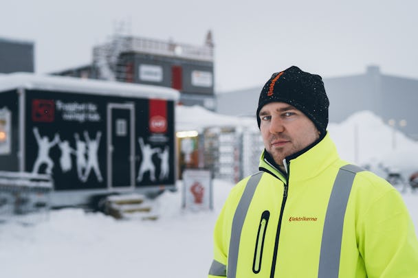 Mathias Hansson framför arbetarplatsens baracker utomhus i snön