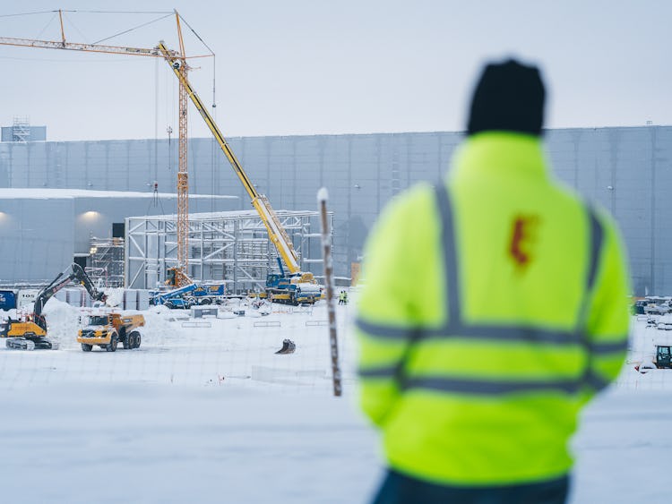 Mathias Hansson utomhus i snön, med arbetsplatsen i bakgrunden