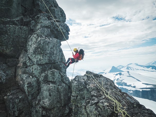 En person klättrar på en klippvägg med säkerhetslina
