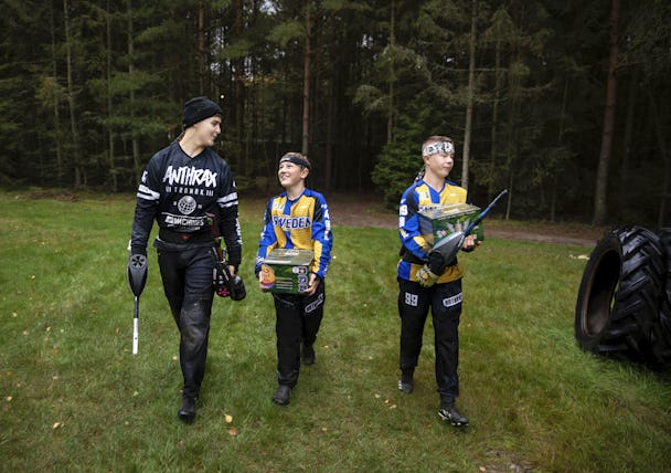Sammi Andersson och bröderna Vigor och Truls Persson bär utrustning utlmhus.