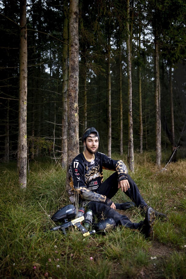Alex Larsson med sin paintball-utrustning i skogen.