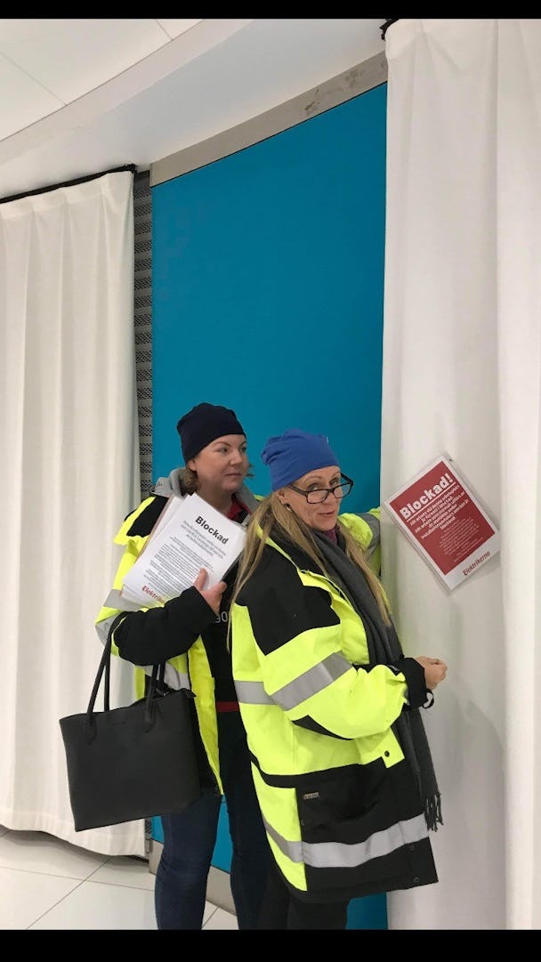 Camilla Lodin och Kristin Zetterlind sätter upp blockadskyltar på arbetsplatsen