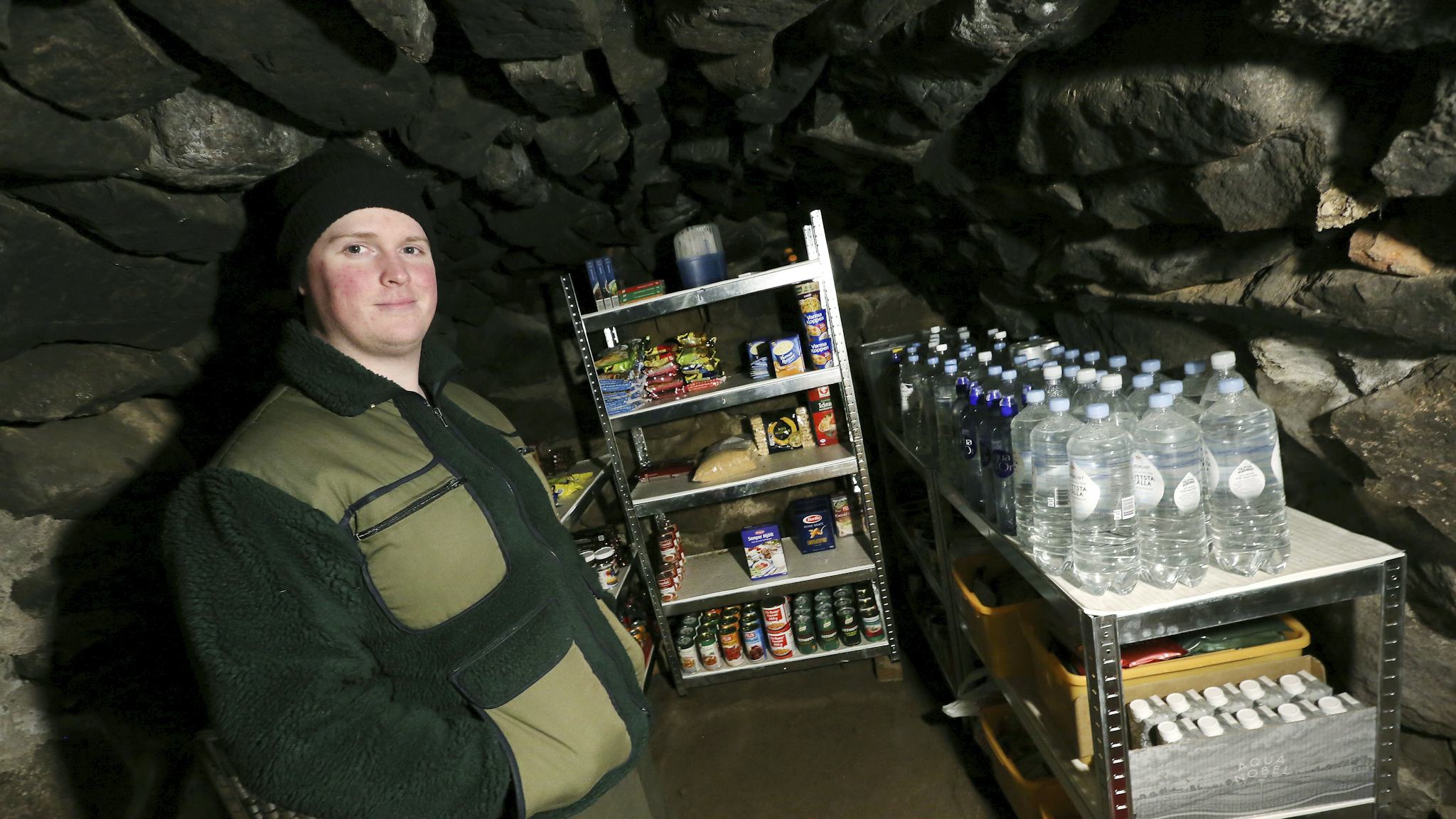 Jacob Törnfeldt i sin källare med hyllorna fulla av mat och vatten.