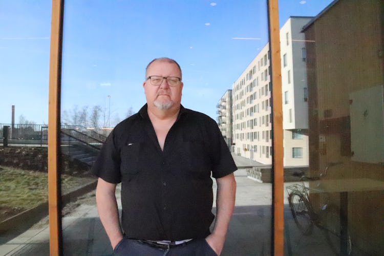 Håkan Johansson framför ett lägenhetshus