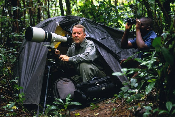 Dick Persson kommer ut ur ett tält i djungeln med sin kamera.