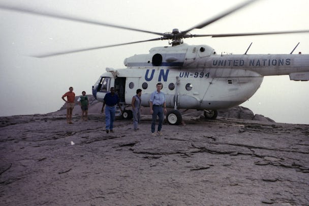 En samling människor framför en helikopter.