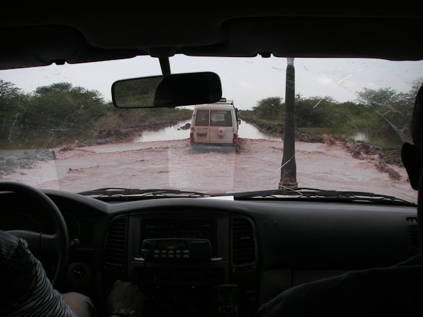 En översvämmad väg sedd genom vindrutan på en bil.