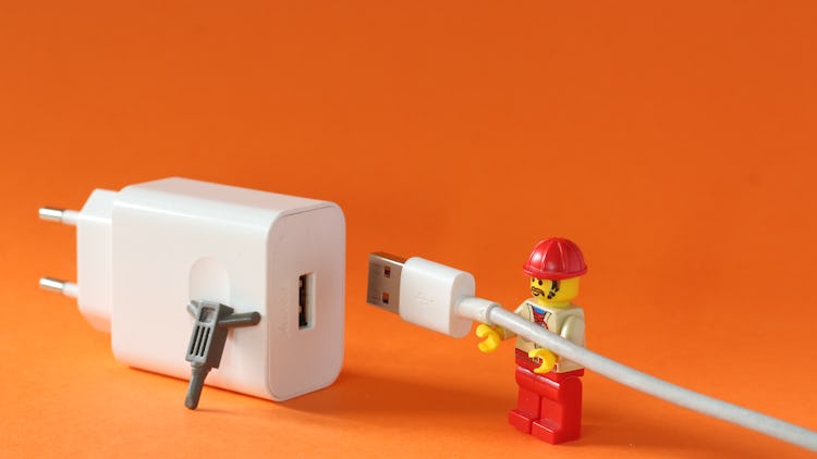 En legofigur kopplar in en USB-sladd i ett uttag.