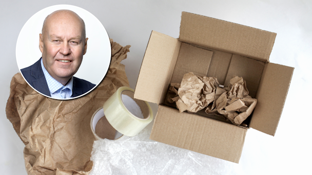 Anders Gustin invid en bild på en låda som är tom förutom lite förpackningsmaterial.