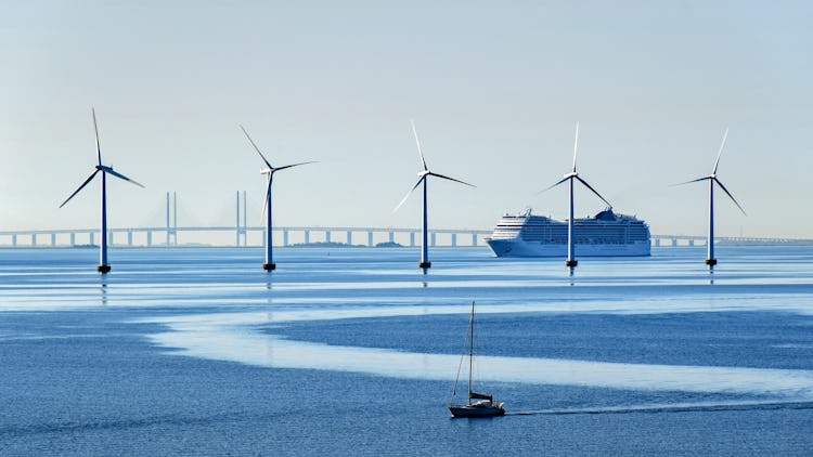 Vindkraftverk, en stor båt, en liten båt, och en Öresundsbro.