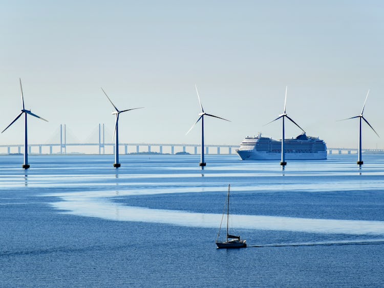 Vindkraftverk, en stor båt, en liten båt, och en Öresundsbro.