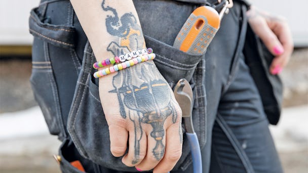 Ellen Brännvalls högra hand, med tatuering och ett armband som det står mamma på.