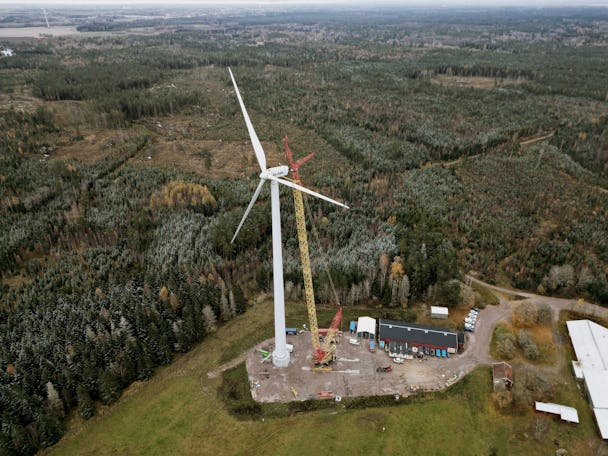 En flygfoto över ett vindkraftverk i en skog.