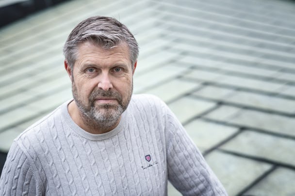 Niklas Enström som står på ett tak i grå tröja.