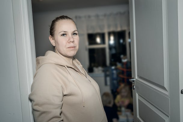 Sandra Wiman i en brun hoodie som står i en dörröppning.