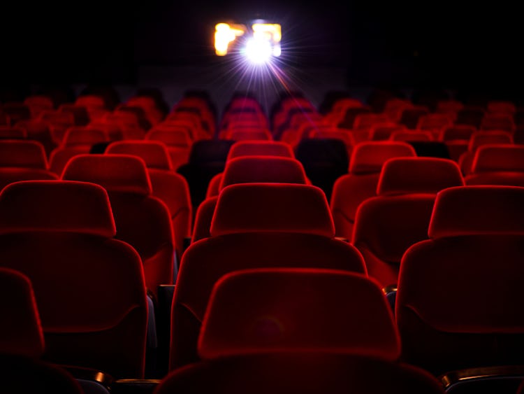 En rad röda stolar i en biograf.