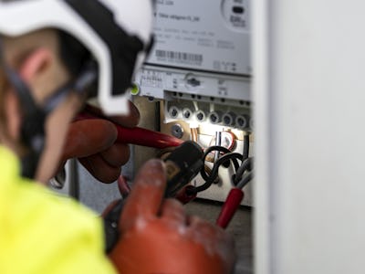 En elektriker arbetar på en elektrisk panel.