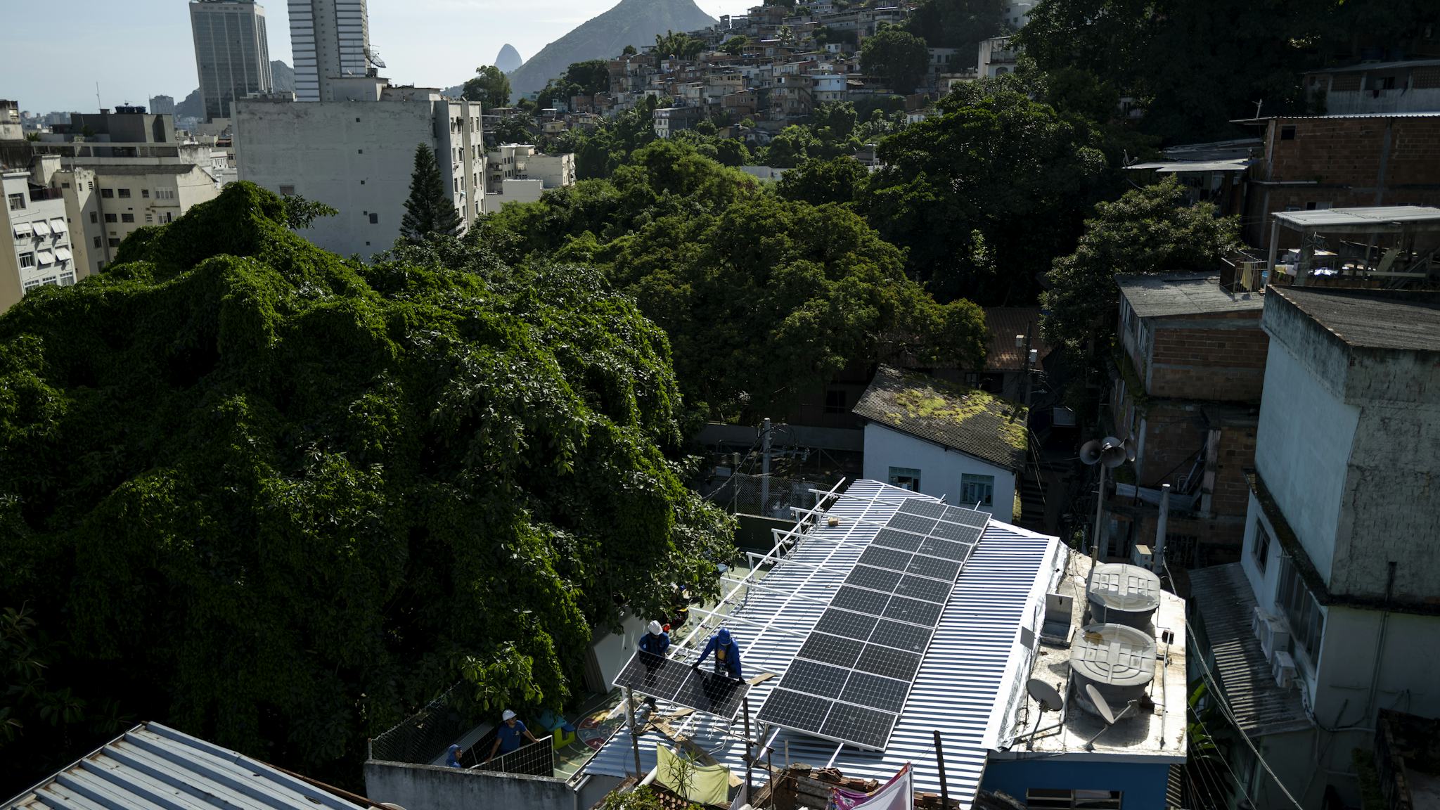 Installation av solpaneler på ett tak i en tätort.