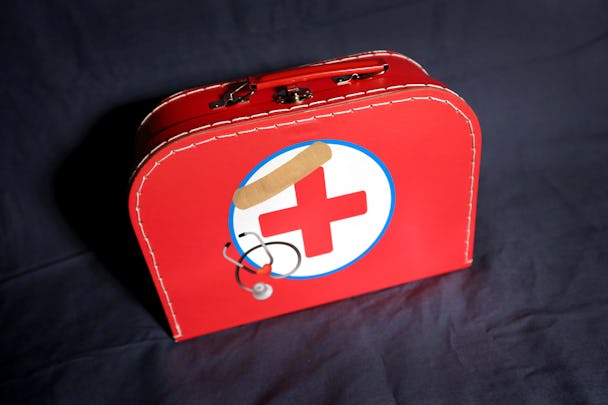 En röd leksaks-läkarvästa med röda korset på