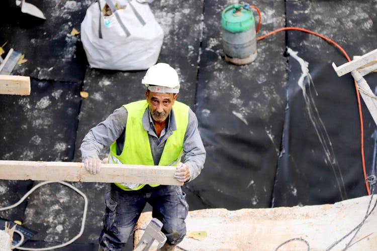 En man i bygghjälm och reflexväst på en byggarbetsplats