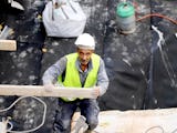 En man i bygghjälm och reflexväst på en byggarbetsplats