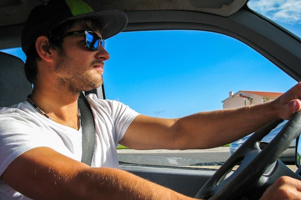 En person i solglasögon som kör bil