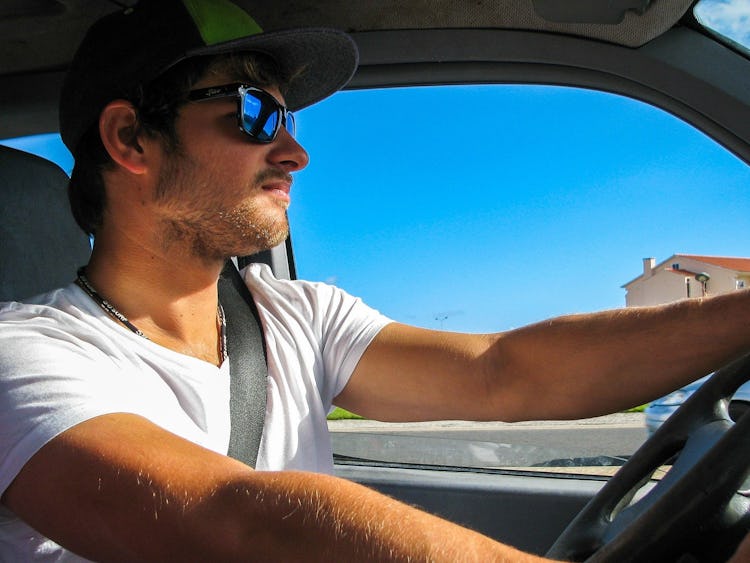 En person i solglasögon som kör bil
