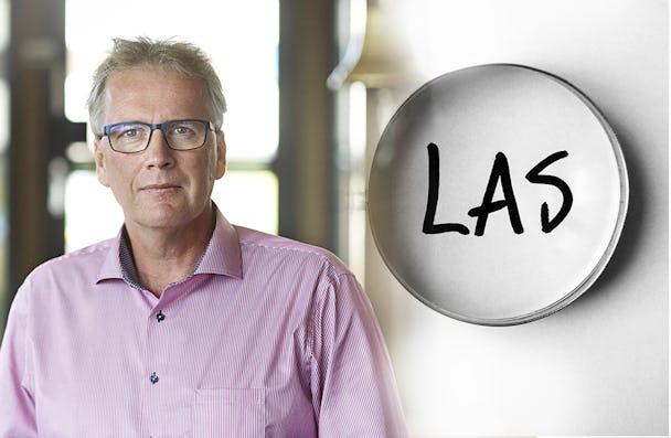 Ett foto av Mikael Johansson monterat invid ett förstoringsglas som zoomar in på ordet LAS