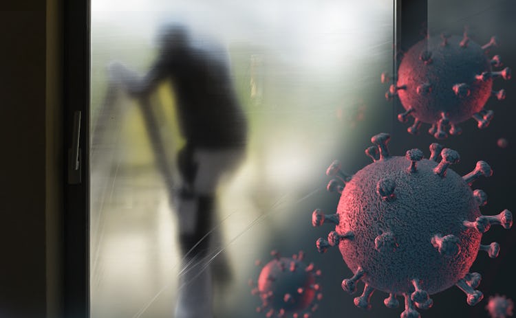 Silhuetten av en målare bakom en skyddsplast, med en bild av det nya coronaviruset monterad i hörnet