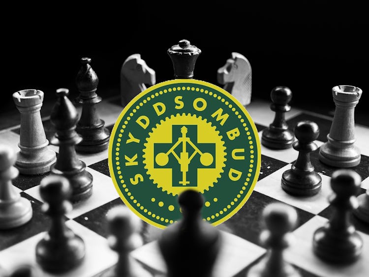 Ett schackbräde med skyddsombuds-symbolen monterad i mitten