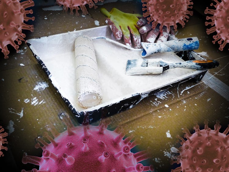 En samling målarverktyg i ett roller-tråg, med bilder av det nya coronaviruset monterade över.