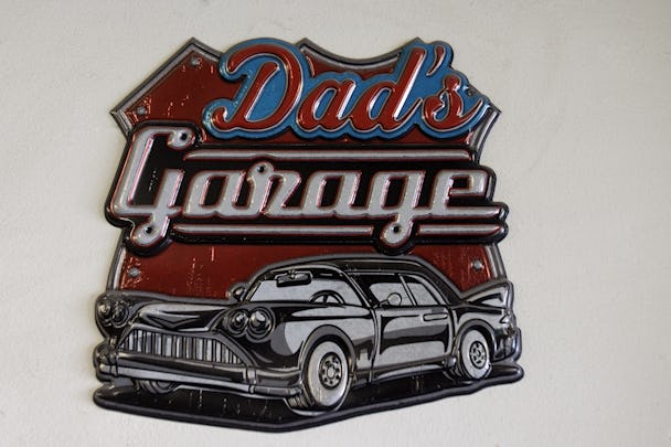En liten skylt med en stiliserad bil och texten: "Dad's Garage"