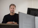 Porträttbild på Peter Sjöstrand vid en datorskärm