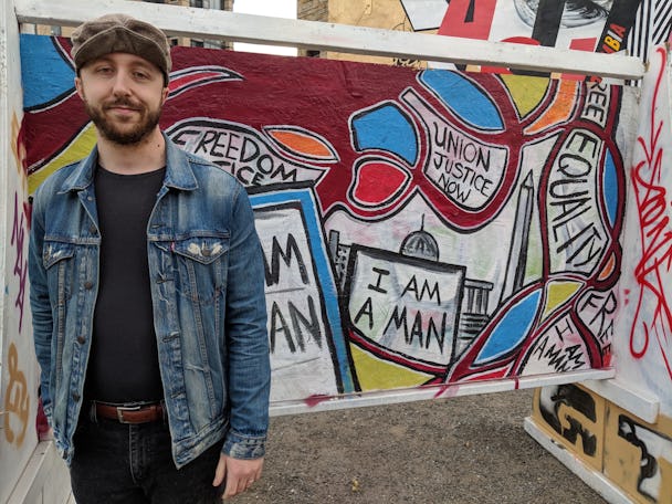 Ryan Kekeris framför en vägg med graffiti