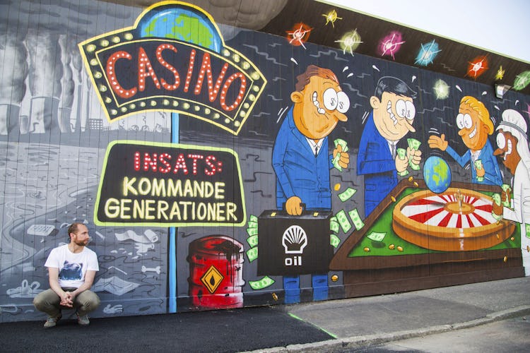 Max Gustafson sitter på marken framför en målad vägg med casino-tema