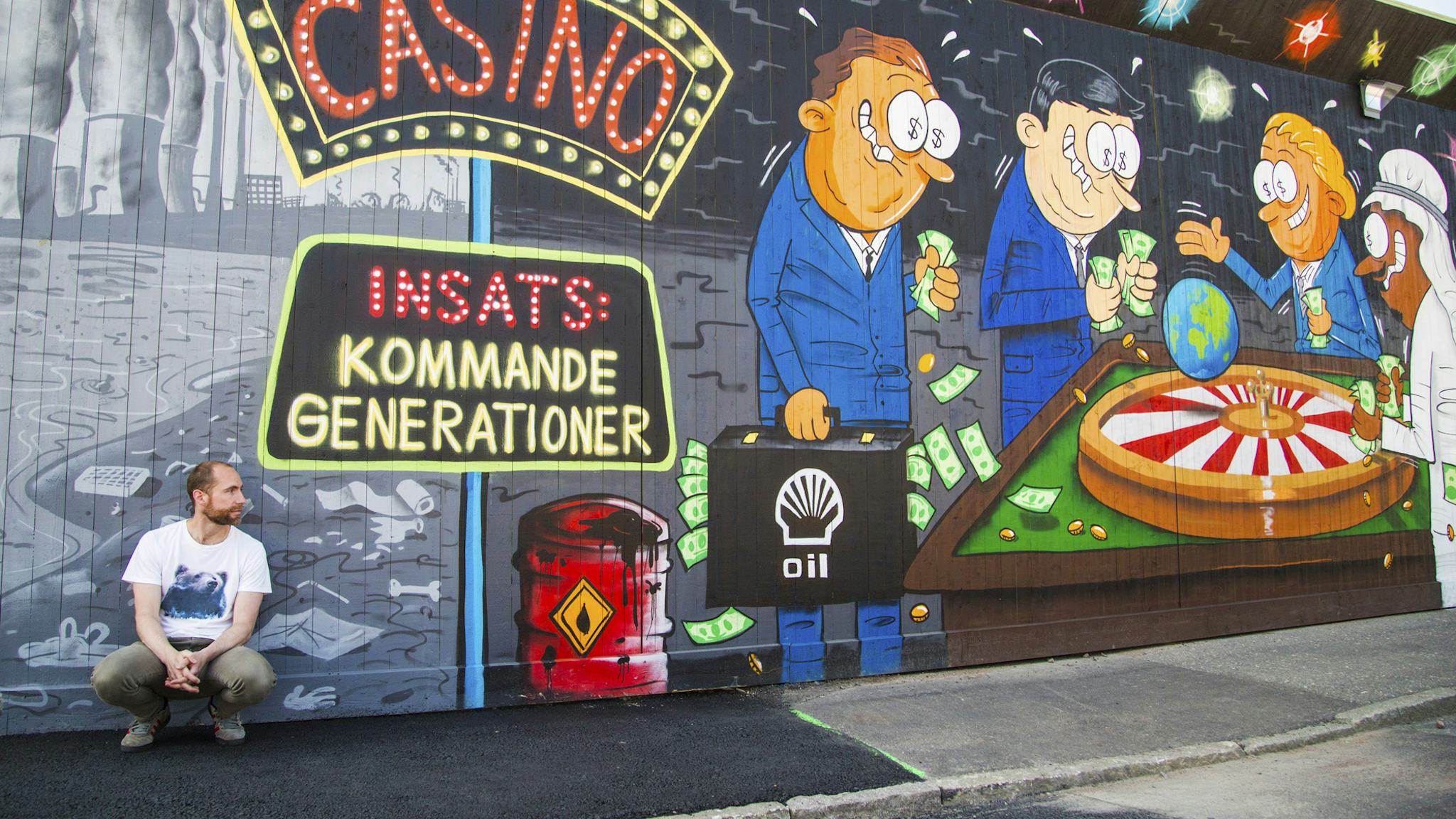 Max Gustafson sitter på marken framför en målad vägg med casino-tema