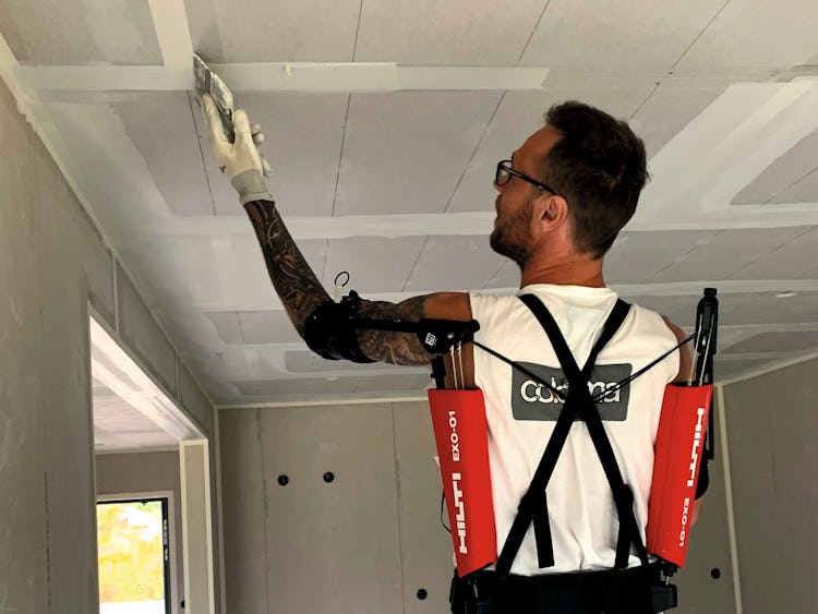 Johnny Brandborg målar ett tak med exoskelettet på sig