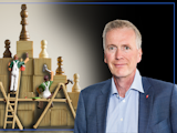 En bild på Mikael Johansson invid en bild på två leksaker i form av målare som målar en pyramid av träklossar med schackpjäser på. Högst upp står kung-pjäsen.