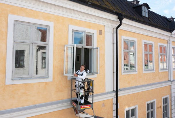 Henrik Karlsson i en skylift vid en husfasad