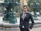Jenny Brodin framför en fontän i en stad