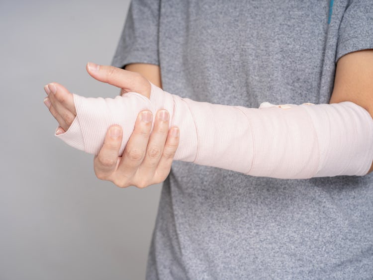 En person håller om sin bandagerade arm